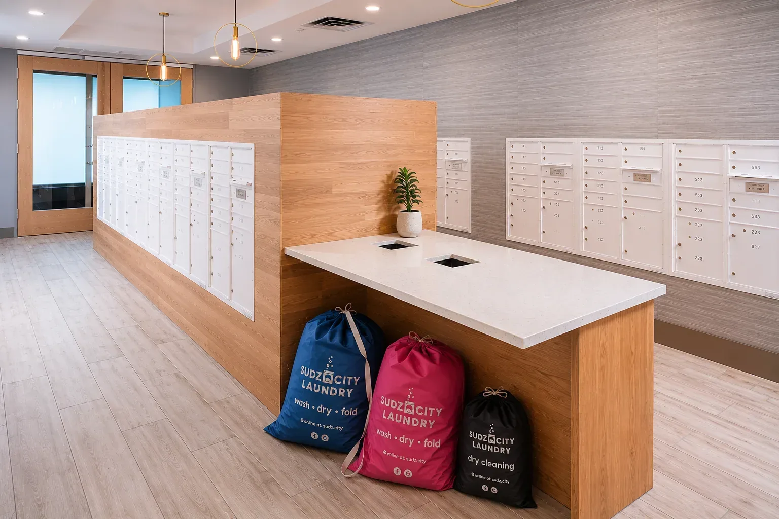 Sudz City laundry bags in a modern apartment mailroom pickup area