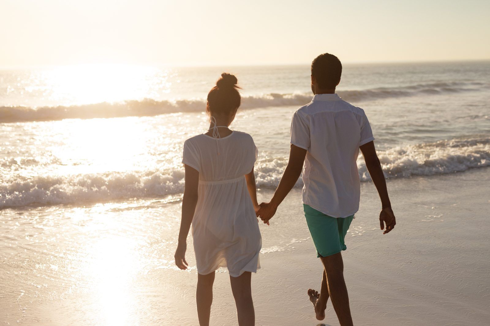 couple walking on the beach at sunset